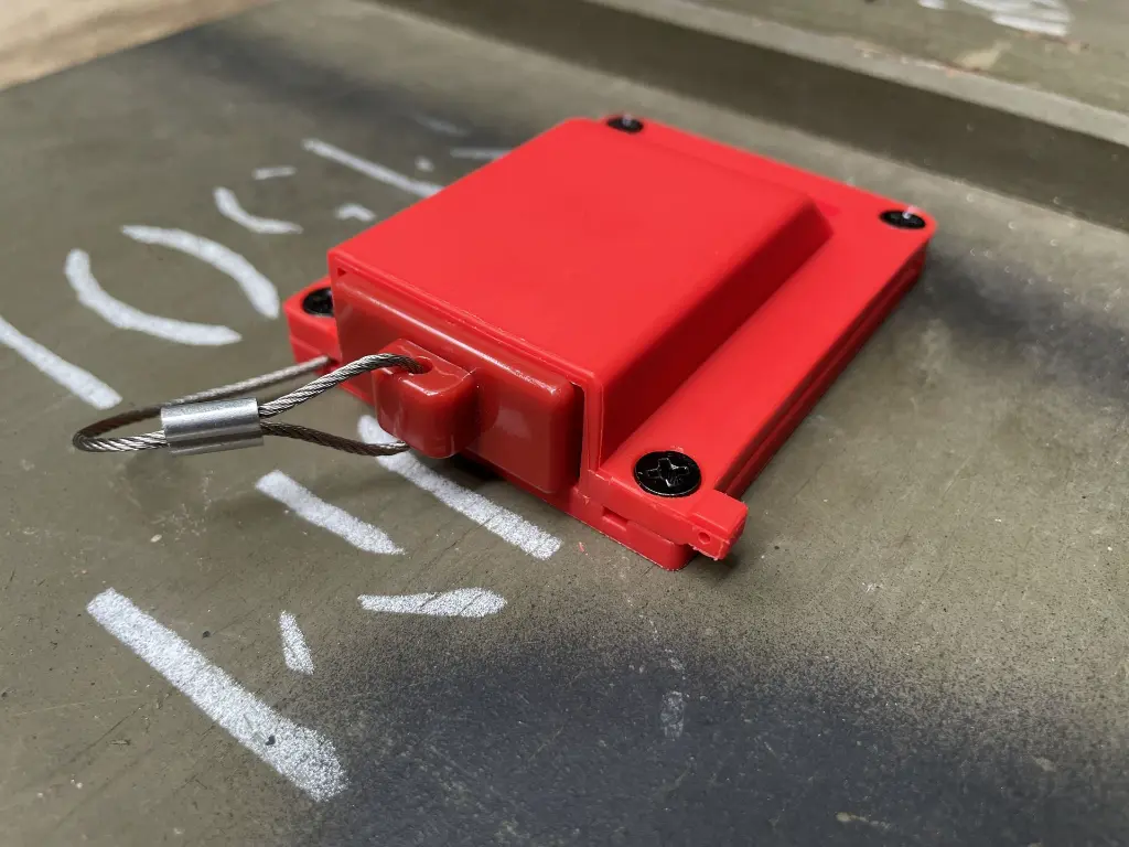 The SORSHA red housing mounted to a panel with its cable exiting the side