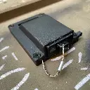 The front of the WRAITH housing with the dust cap closed over the connector recess, wire rope tether visible beside it
